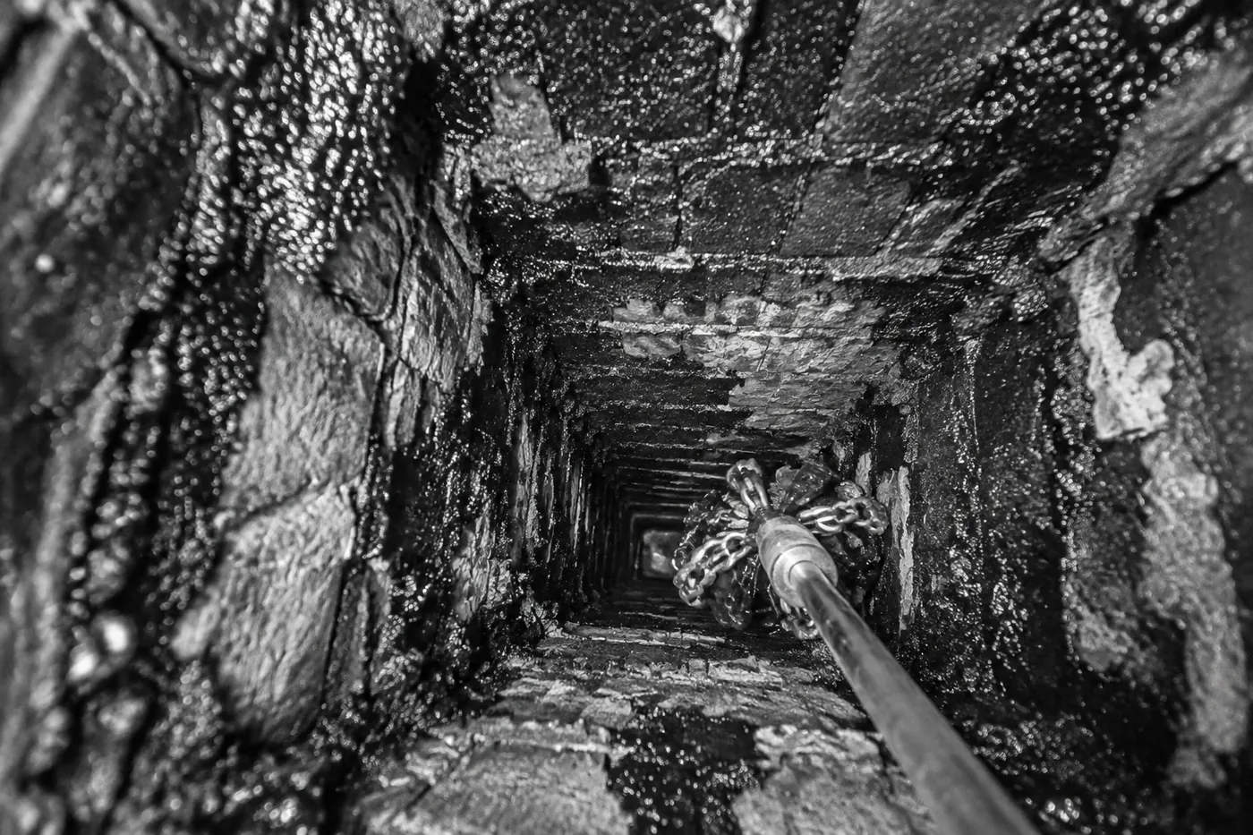 Paroi intérieure d’un conduit de fumée couverte d’un dépôt noir et brillant de bistre