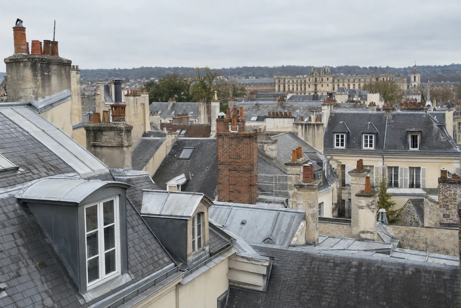Toits d’ardoise, lucarnes et souches de cheminée en brique d’une ville ancienne des Yvelines